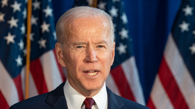 Joe Biden speaking in front of American flags