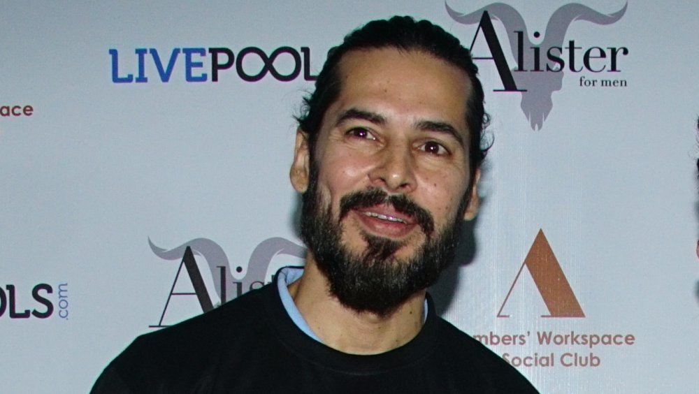 Dino Morea with hair pulled back, looking off camera