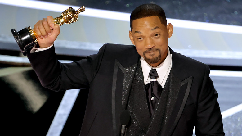 Will Smith holds up his Best Actor Oscar on stage