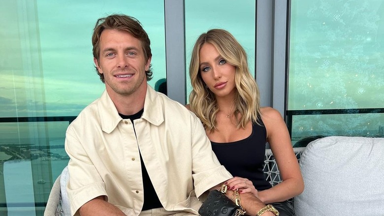 Braxton Berrios and Alix Earle sit in front of a window