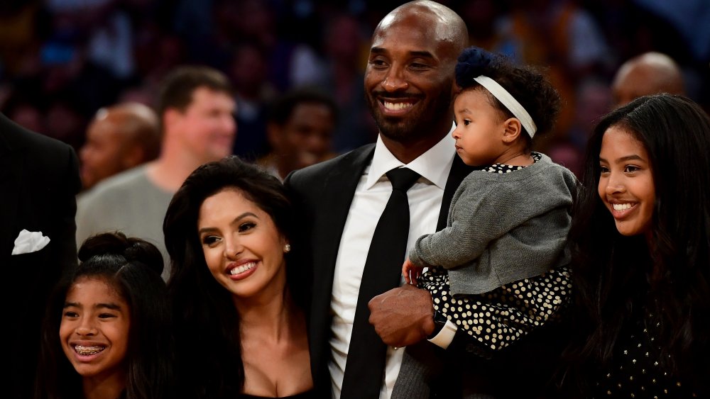 Kobe Bryant poses with his family at halftime after both his #8 and #24 Los Angeles Lakers jerseys are retired