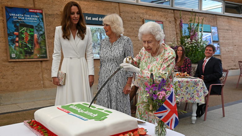 Queen Elizabeth cuts a cake 