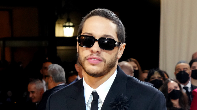 Pete Davidson posing in sunglasses and a suit