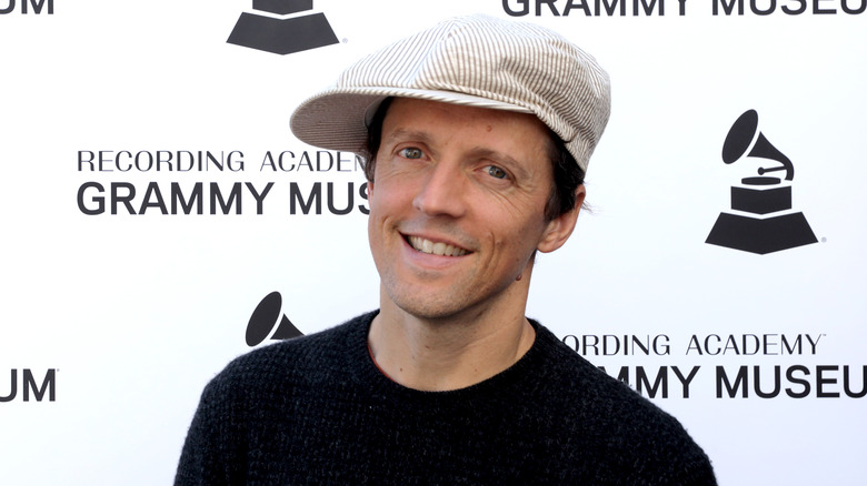 Jason Mraz smiling wearing a newsboy cap