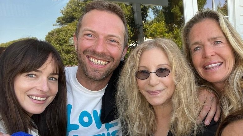 Dakota Johnson and Chris Martin posing with Barbra Streisand