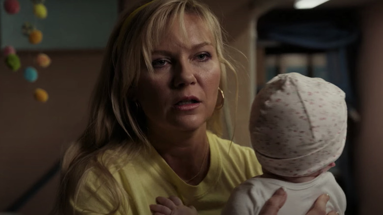 Kirsten Dunst yellow shirt holding baby