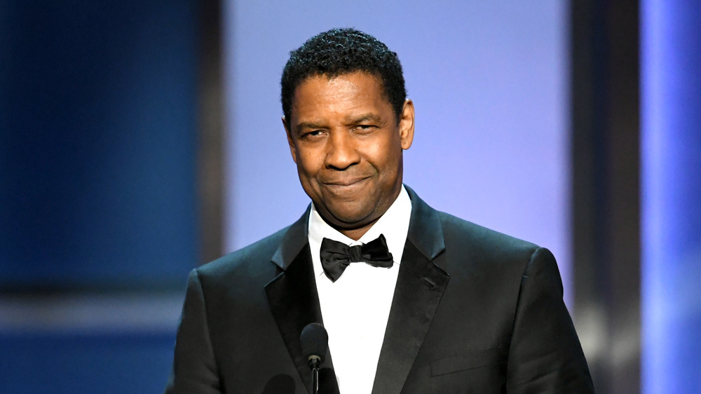 Denzel Washington smiling while making an acceptance speech