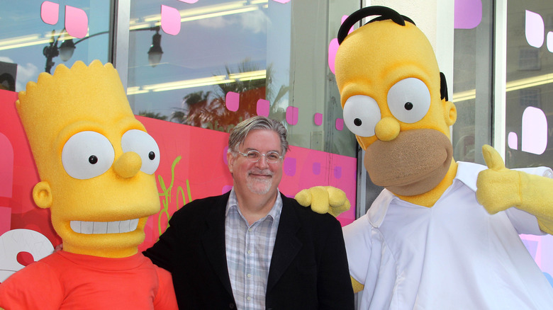 Matt Groening posing with Simpsons mascots