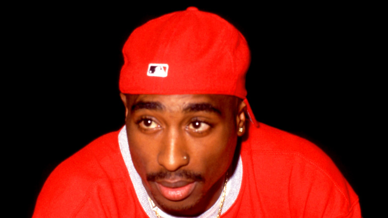 Tupac Shakur posing in red outfit