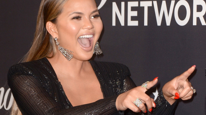 Chrissy Teigen with wide smile at event 