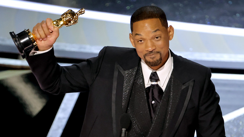 Will Smith holding his Oscar up