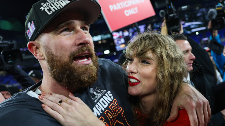 Taylor Swift smiling at Travis Kelce on football field