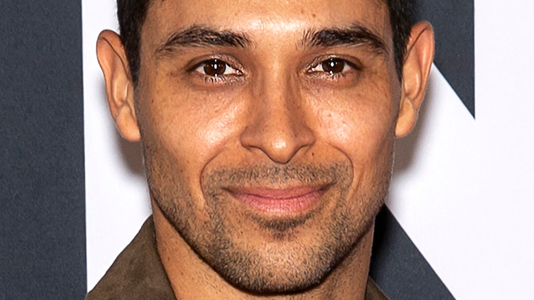 Wilmer Valderrama wears a tan jacket at an event