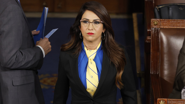 Lauren Boebert wearing a blue dress, yellow tie and black blazer.