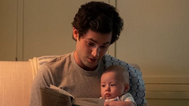 Penn Badgley, as Joe Goldberg, reading to his baby son, Henry