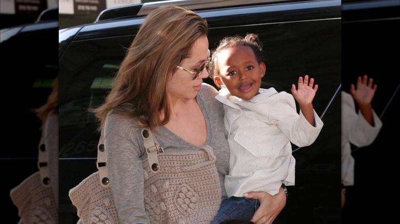 Angelina Jolie holding a young waving Zahara Jolie